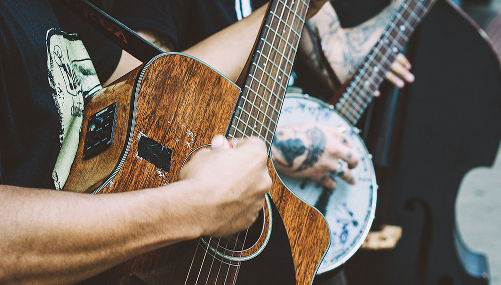 two people playing guitar